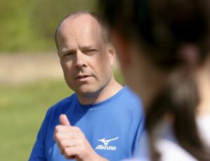 Ein Trainer mit blauem Tshirt erklärt eine Kundin eine Übung.