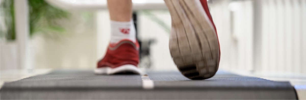 Ein Laufband mit roten Laufschuhen in der Bewegungsanalyse ist zu sehen